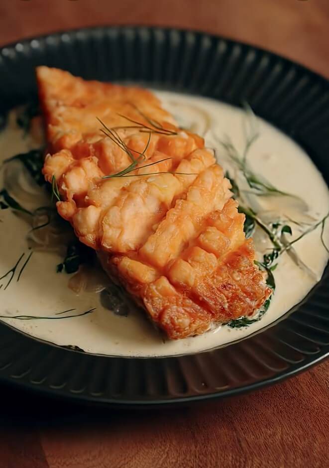 Salmón frito crujiente con salsa cremosa de espinacas